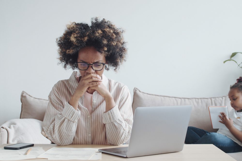 Stressed young african woman doing paperwork - emergency savings