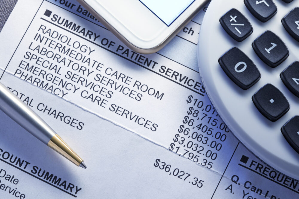 Calculator And Mobile Phone On Top Of Medical Invoice