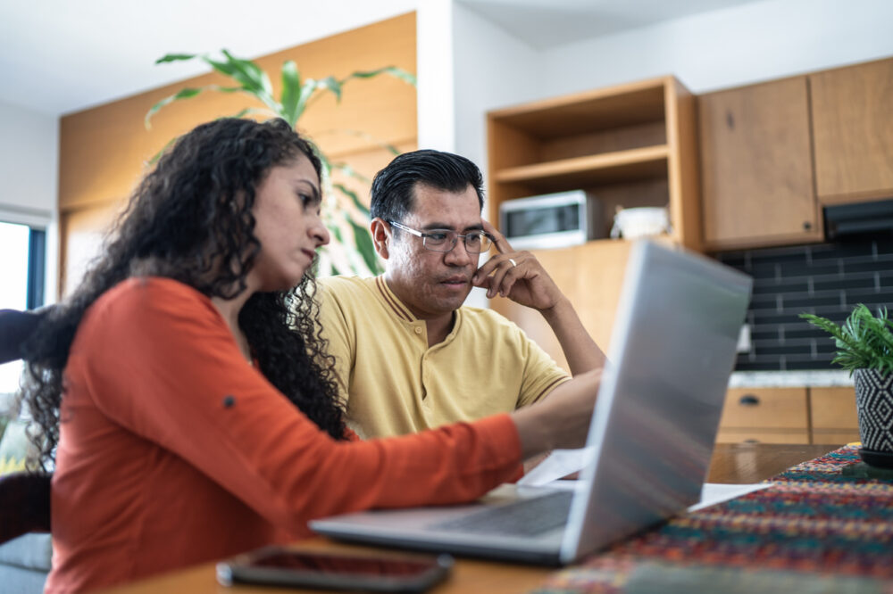 Credit Building in the Digital Age - couple using computer to calculate finances