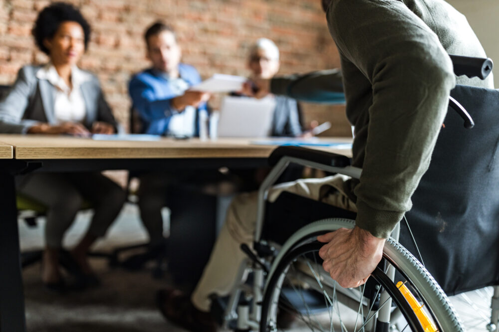 Close up of unrecognizable candidate in a wheelchair on a job interview in the office.