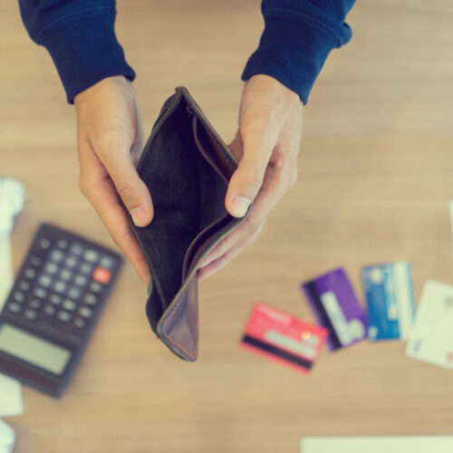 Close up man hand opening empty wallet over calculator