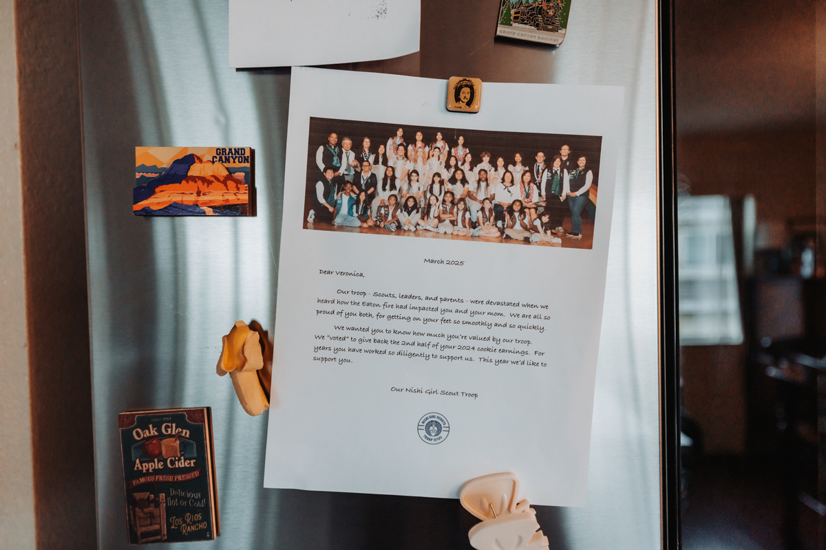 A letter and photo from the girl scout troop put up on Amanda's refrigerator
