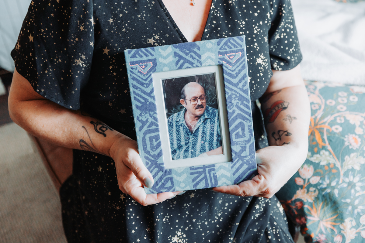 Amanda holding a framed picture of a loved one.