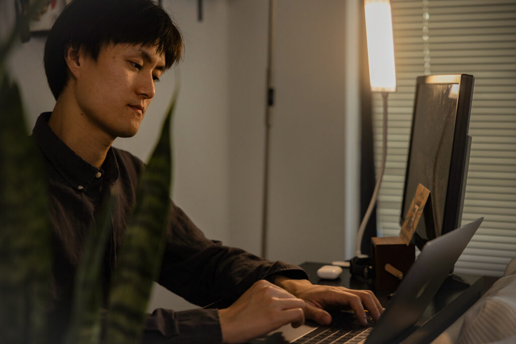 Zerui works on his laptop at home after work applying to jobs