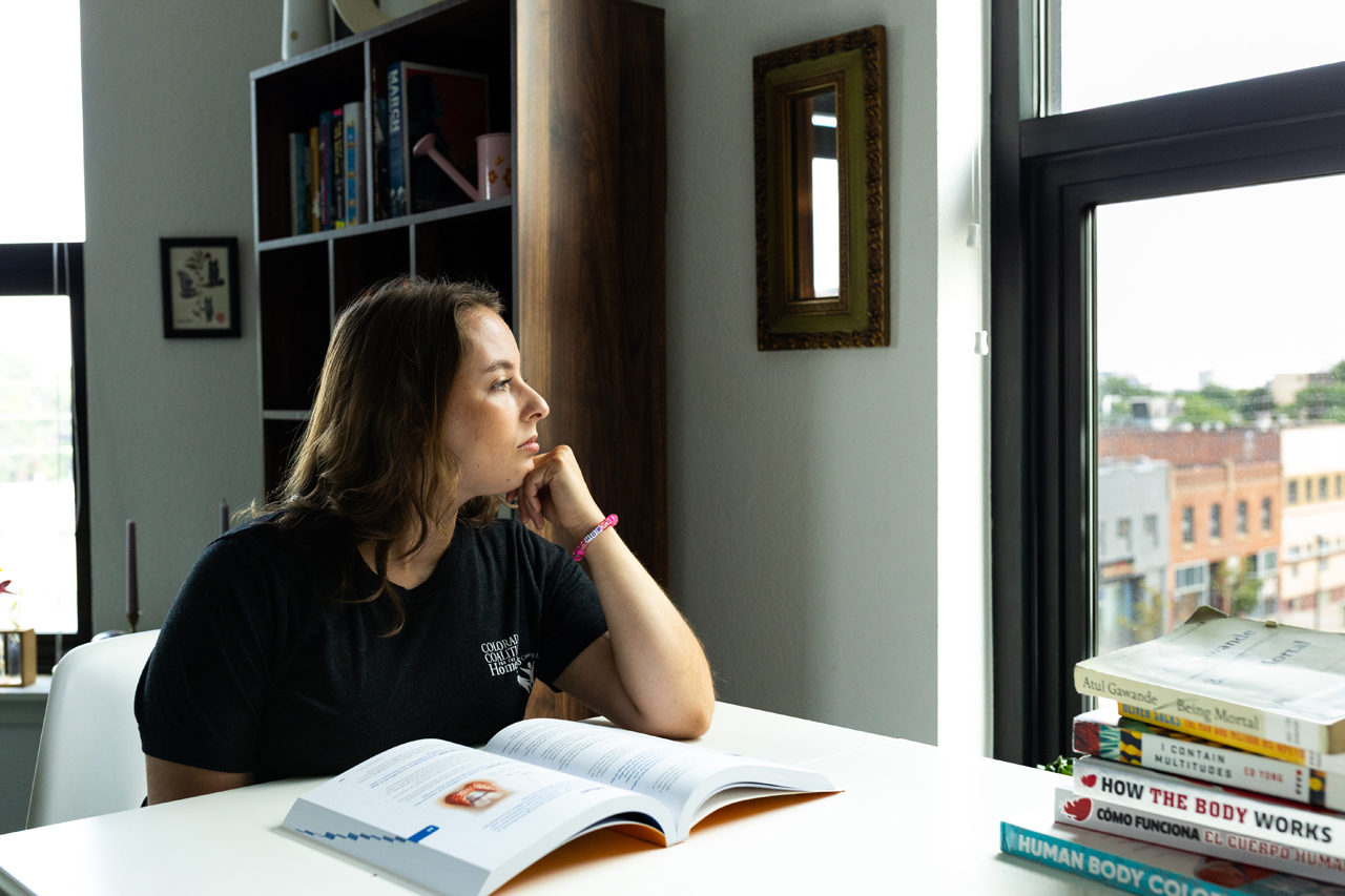 Angel gazes out the window of her home