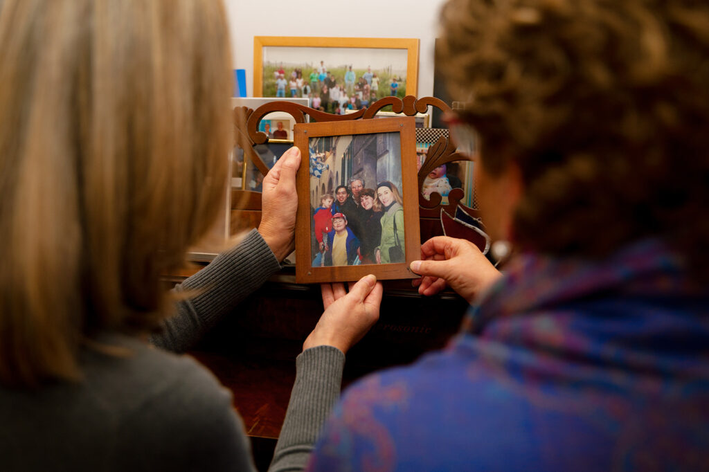 Elizabeth and Linda look at an old framed family photo