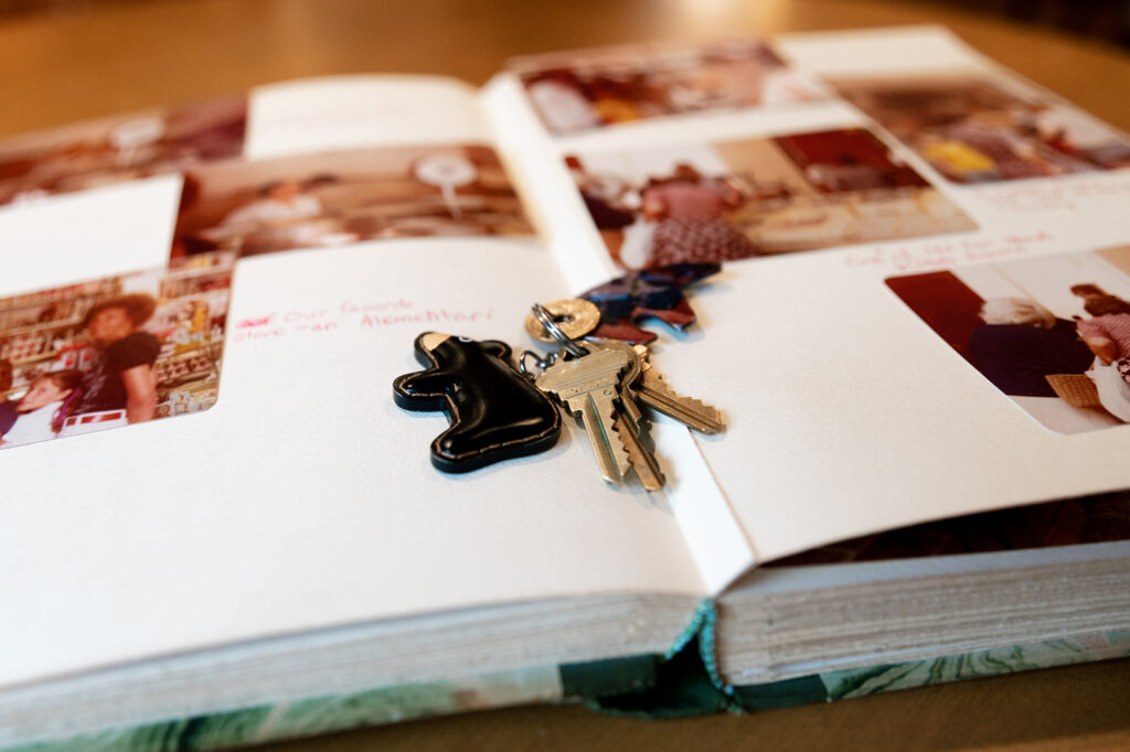 set of keys with a bear keychain lying on top of a photo album