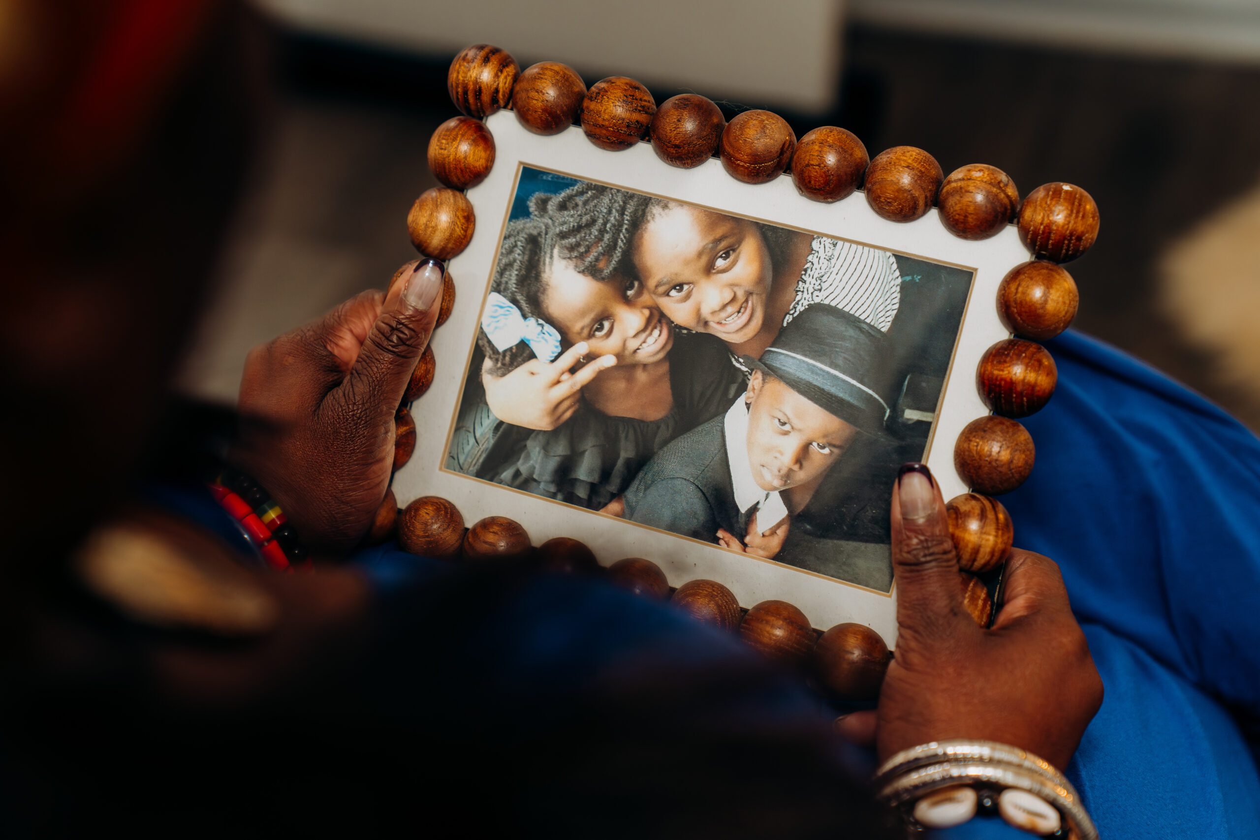 Wande holds a framed photo of her three children