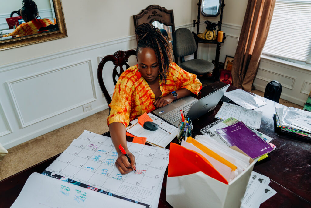 Ori spreads out in her home office with a laptop, files, and a calendar