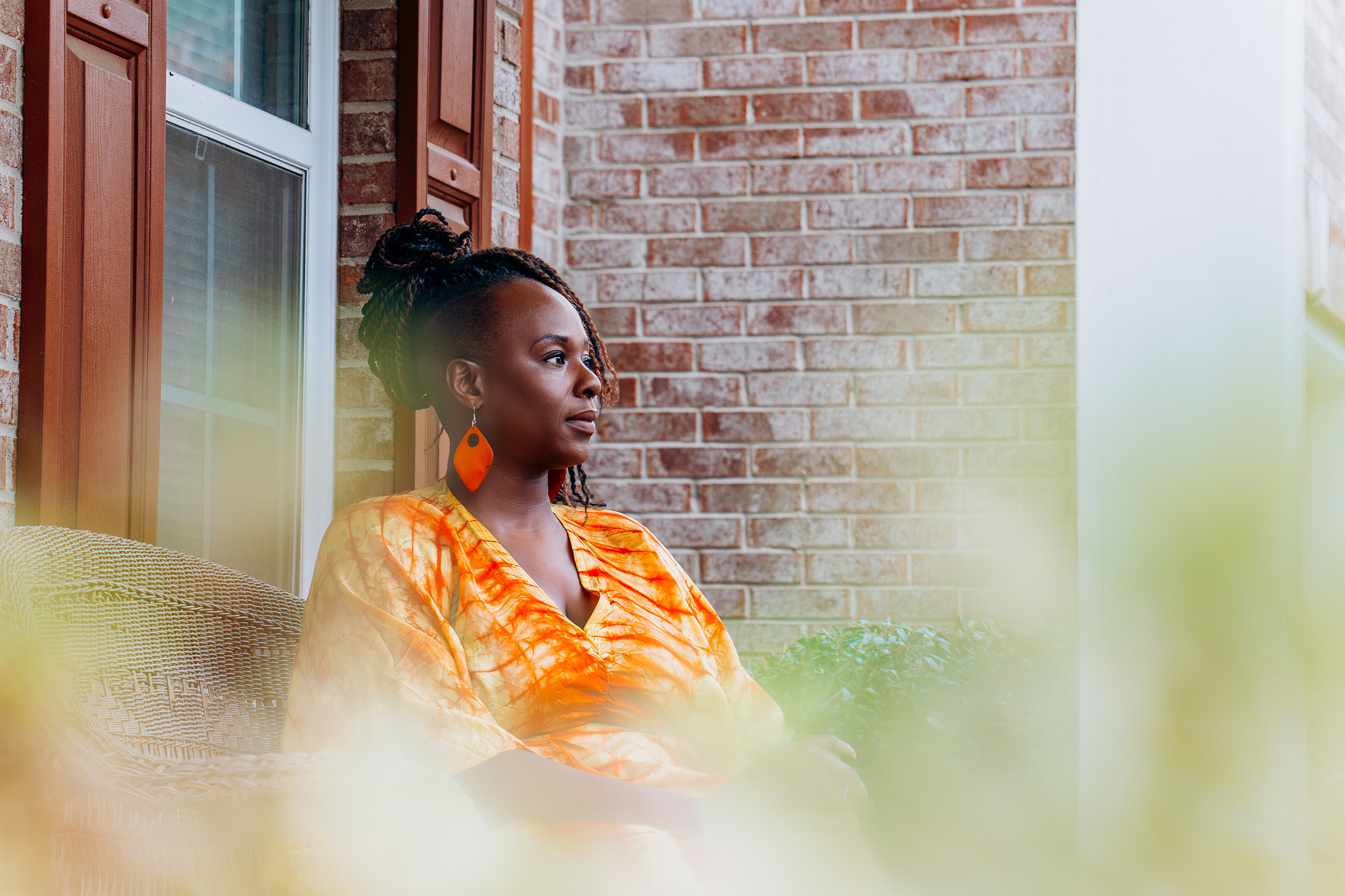 Ori sits on her front porch looking contemplative