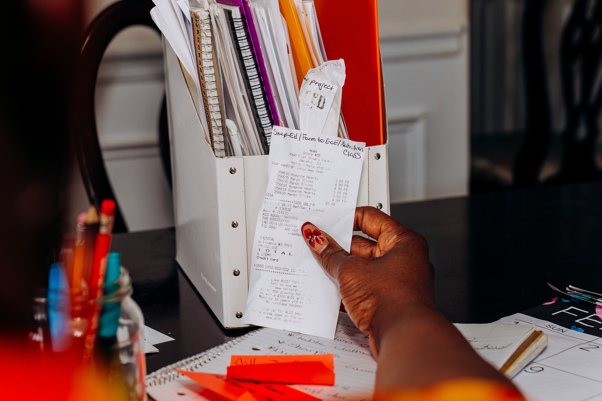 Ori holds a receipt while budgeting