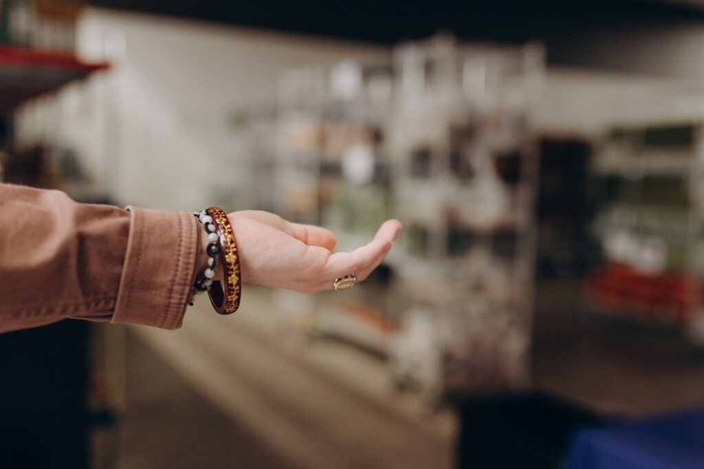 close up of Margarita holding her hand out with the food pantry in the background