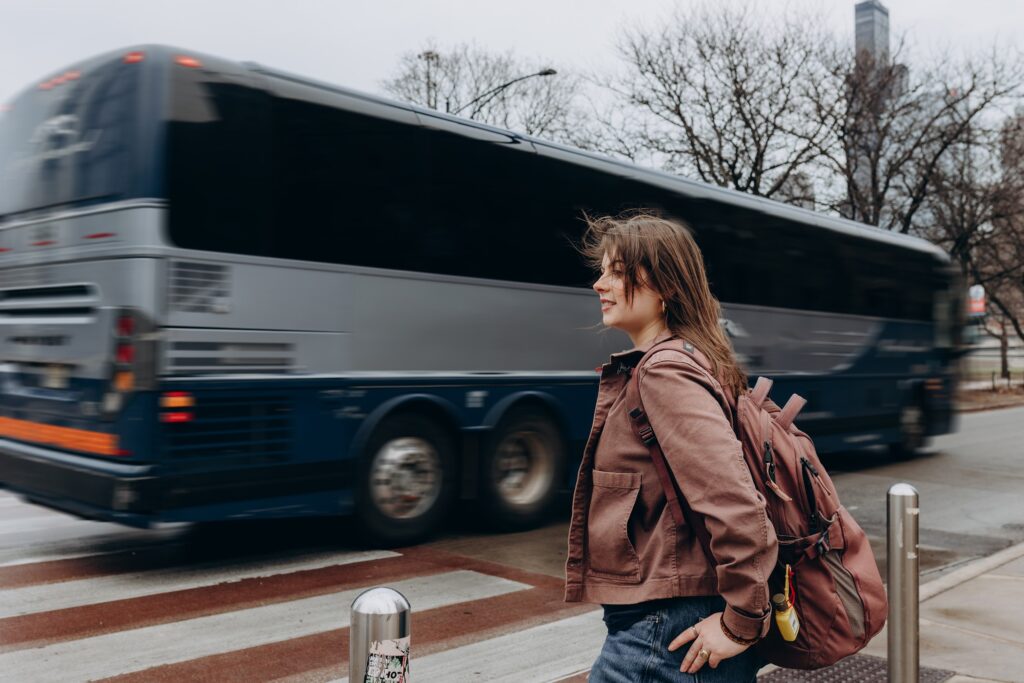 Margarita waits at the crosswalk while a bus drives by