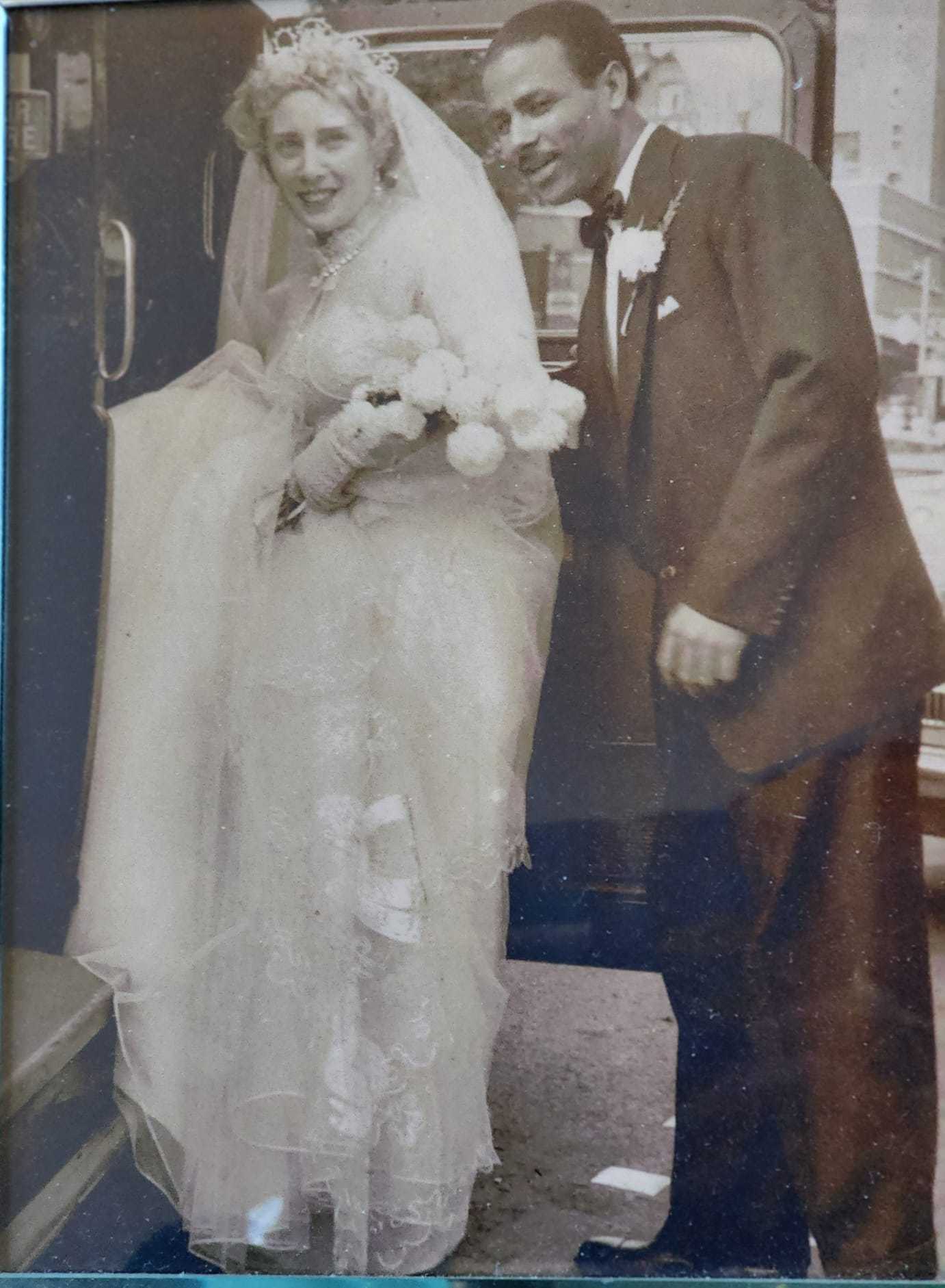 Black and white photo of Fawziah's grandparents on their wedding day getting into a car