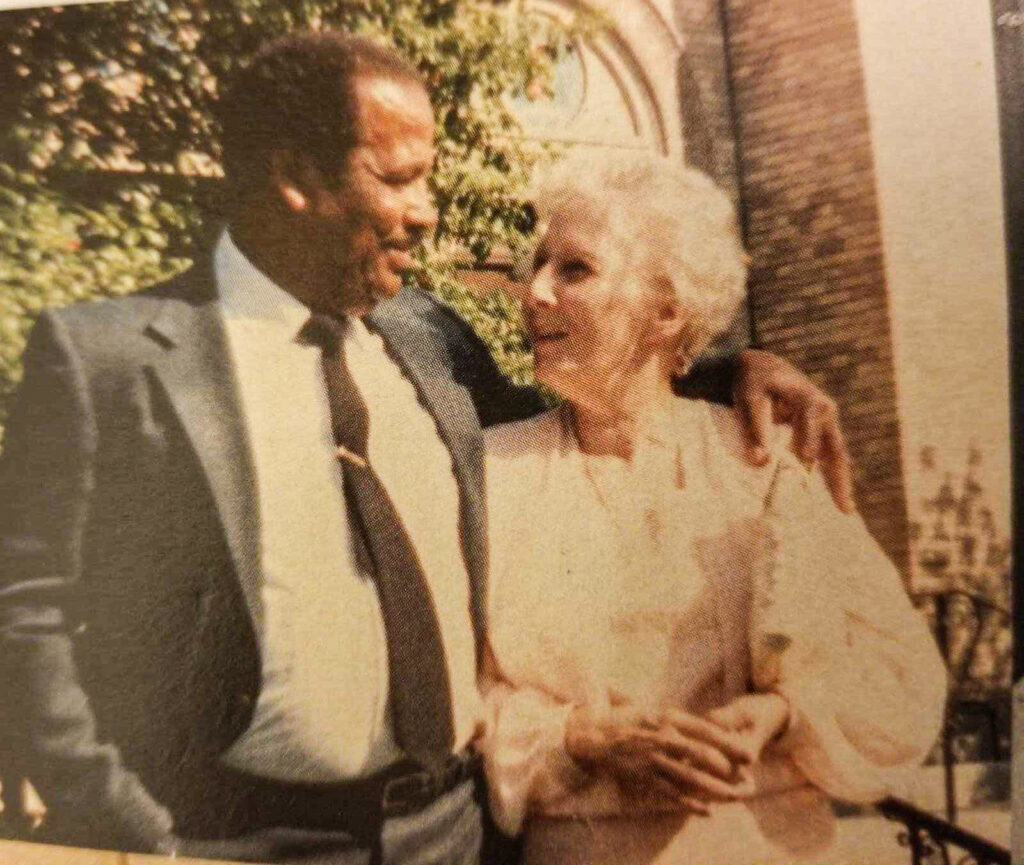 The couple is older and dressed for a special occasion looking fondly at one another